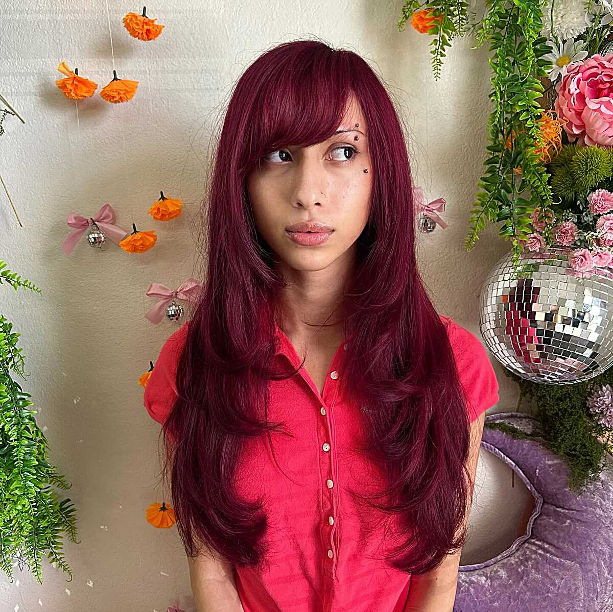 Long burgundy hair with full bangs blending into side layers