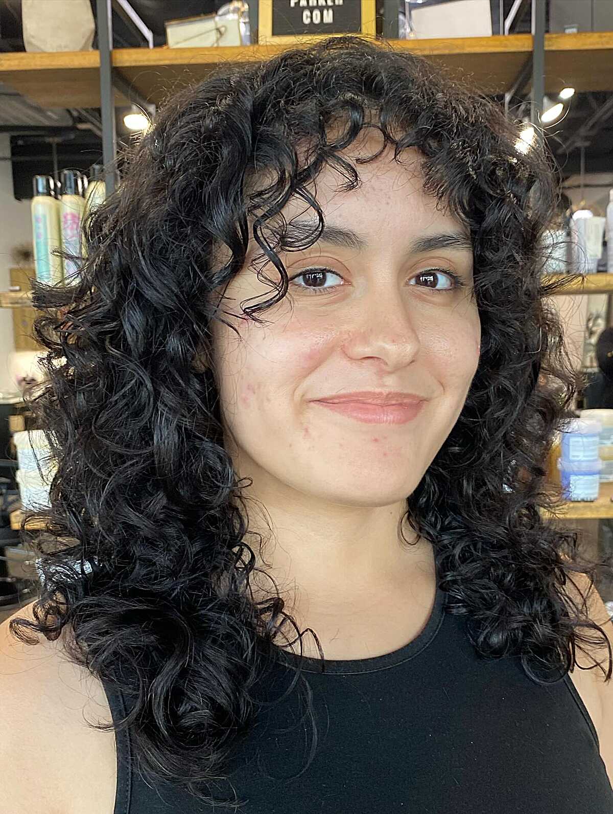 Black curly shag with curly bangs at mid-length