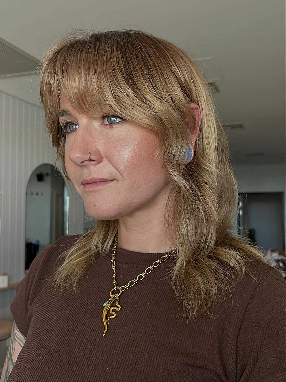 Golden blonde shaggy layers with swoopy bangs