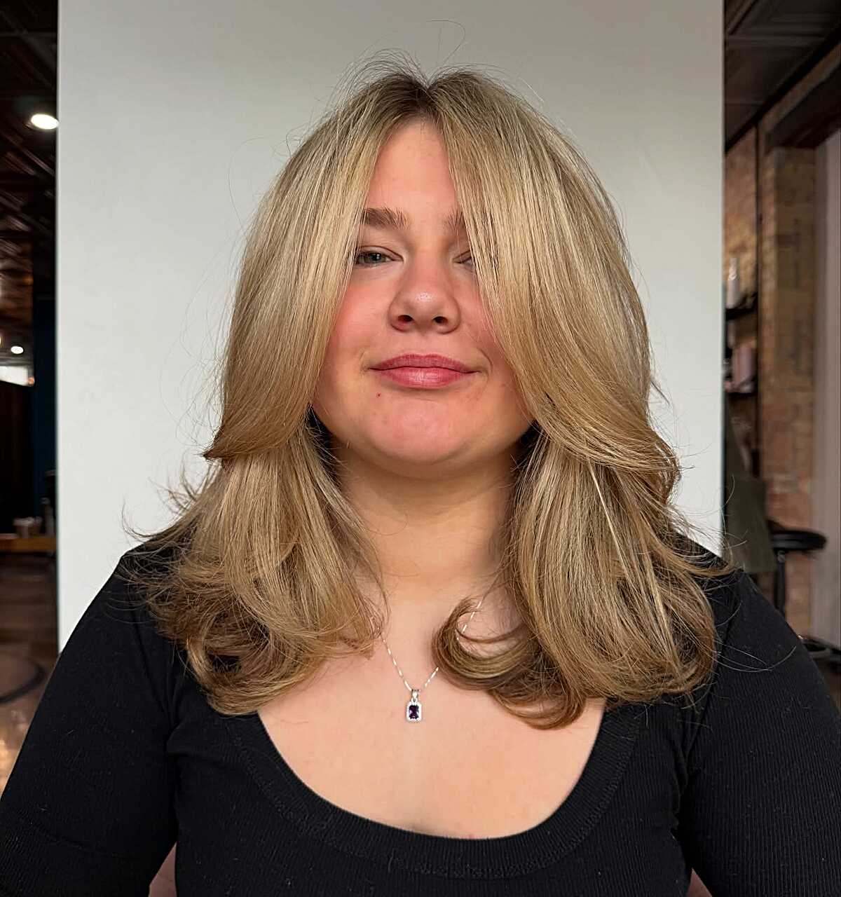 Golden blonde voluminous blowout with curtain bangs
