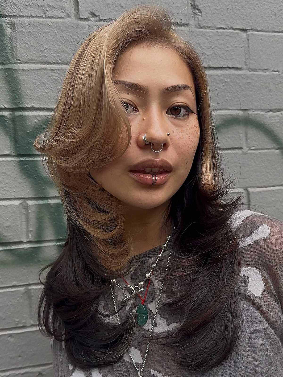 Split-dyed blonde and dark brown with feathered side bangs