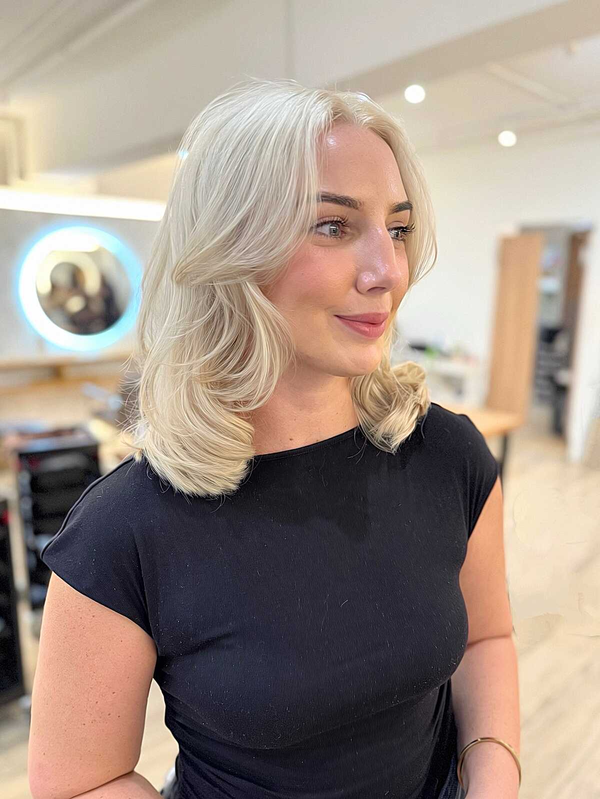 Platinum blonde mid-length blowout with flipped ends