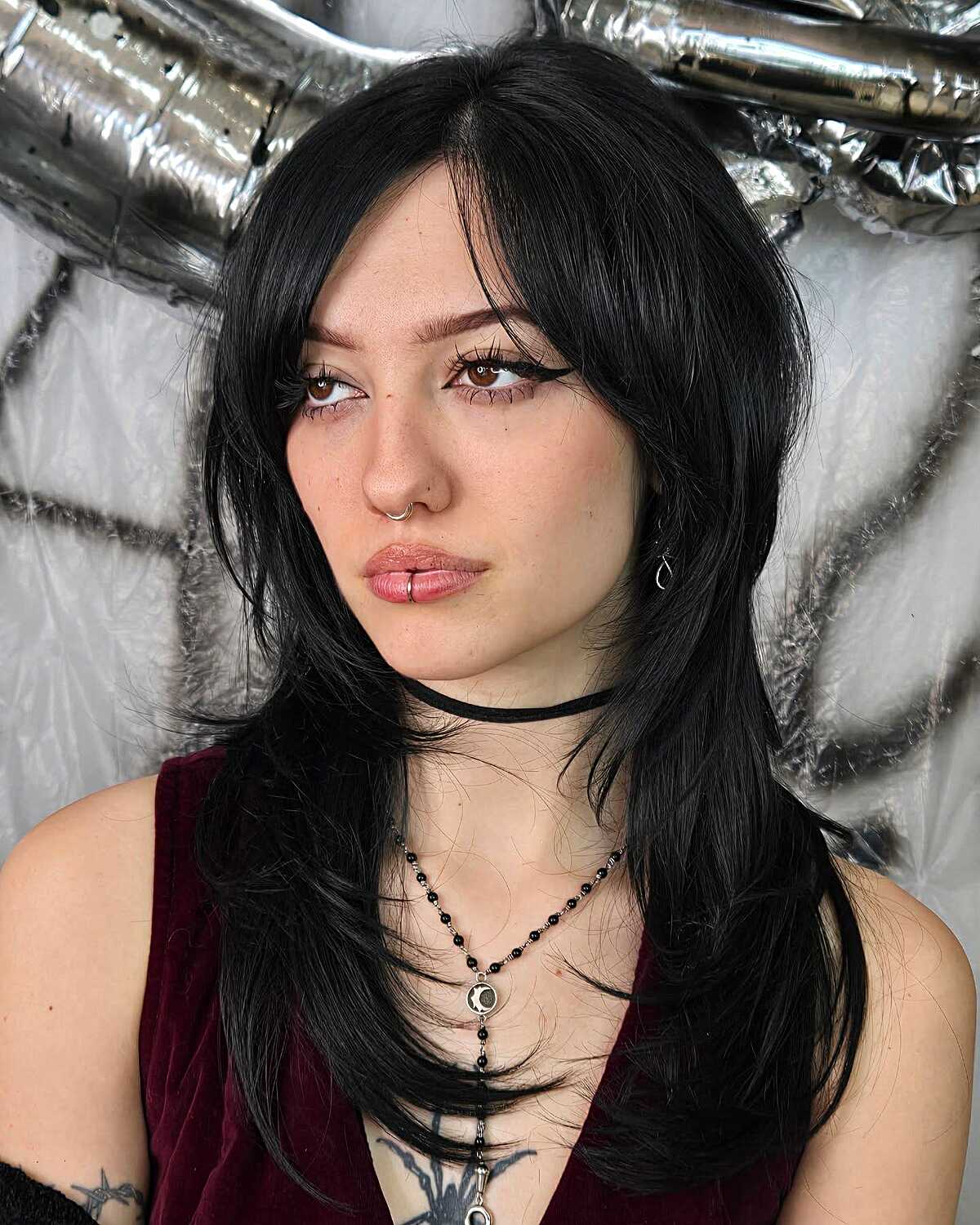 Long black layered hair with side-swept bangs and choppy ends