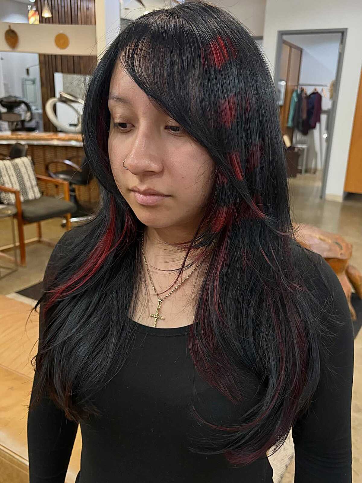 Long jet black hair with thin red peekaboo streaks and bangs