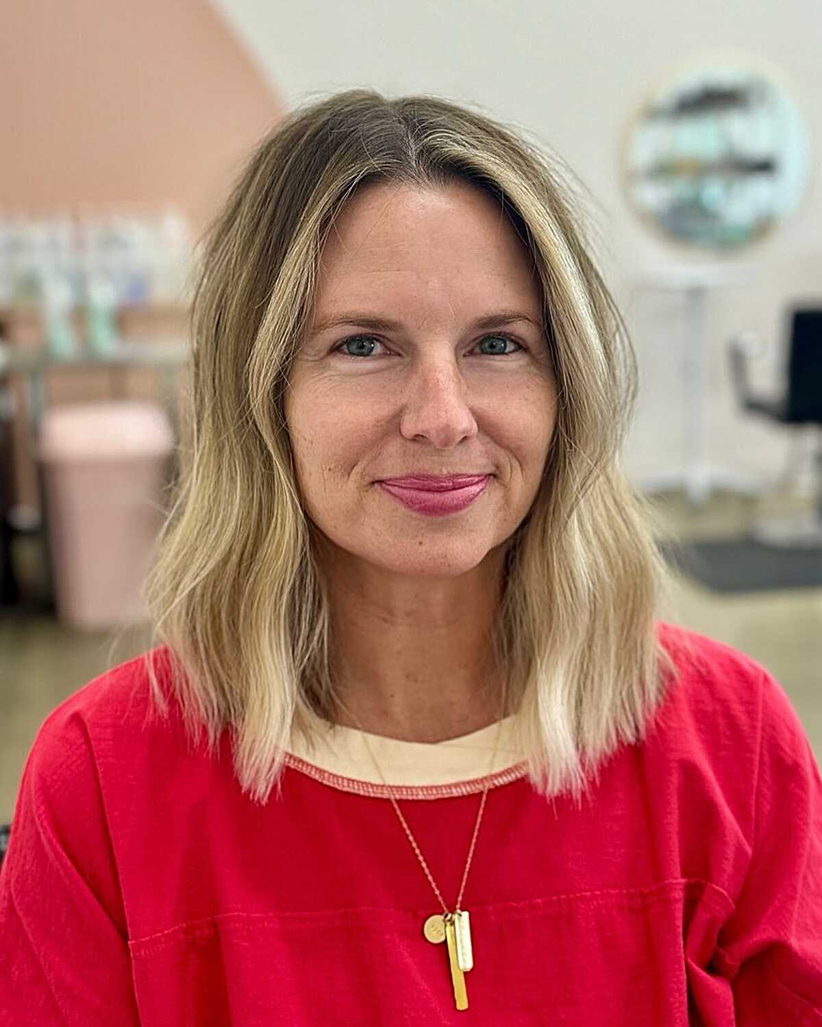 Blonde wavy mid-length hair with center part and texture