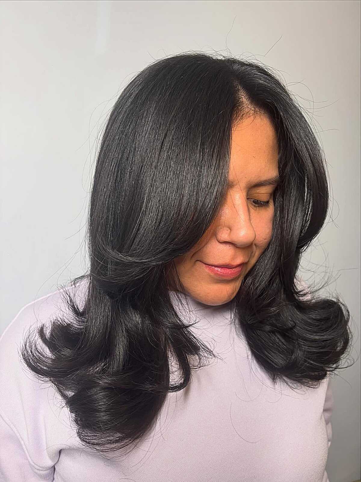 Polished black blowout with barrel curls and side part