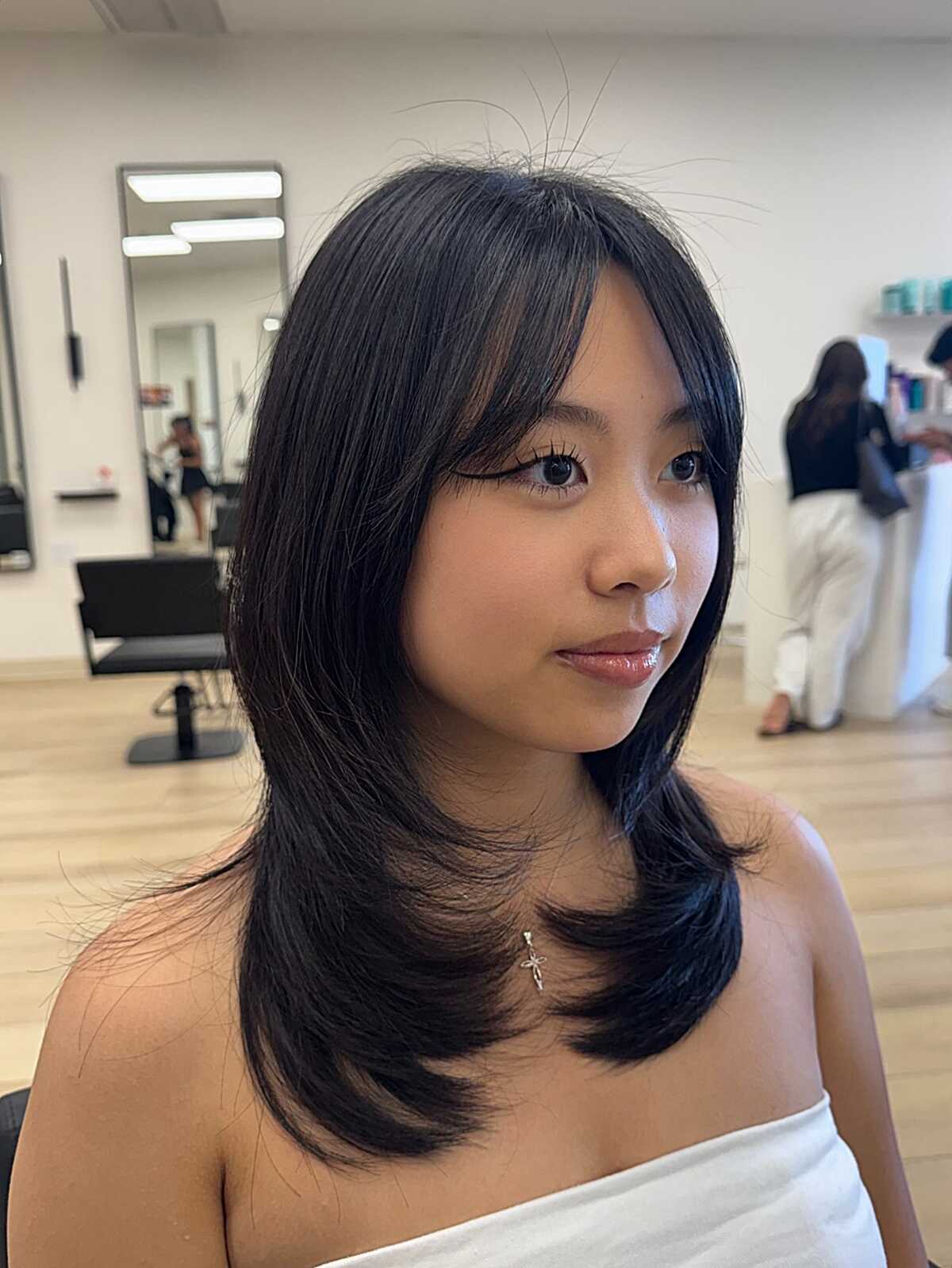 Sleek black layered blowout with long side bangs