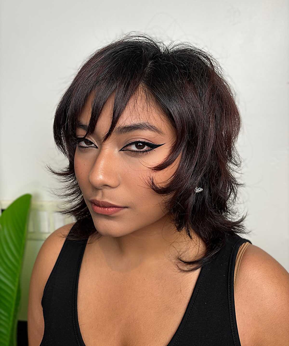 Short dark textured shag with pointed side bang at cheekbone