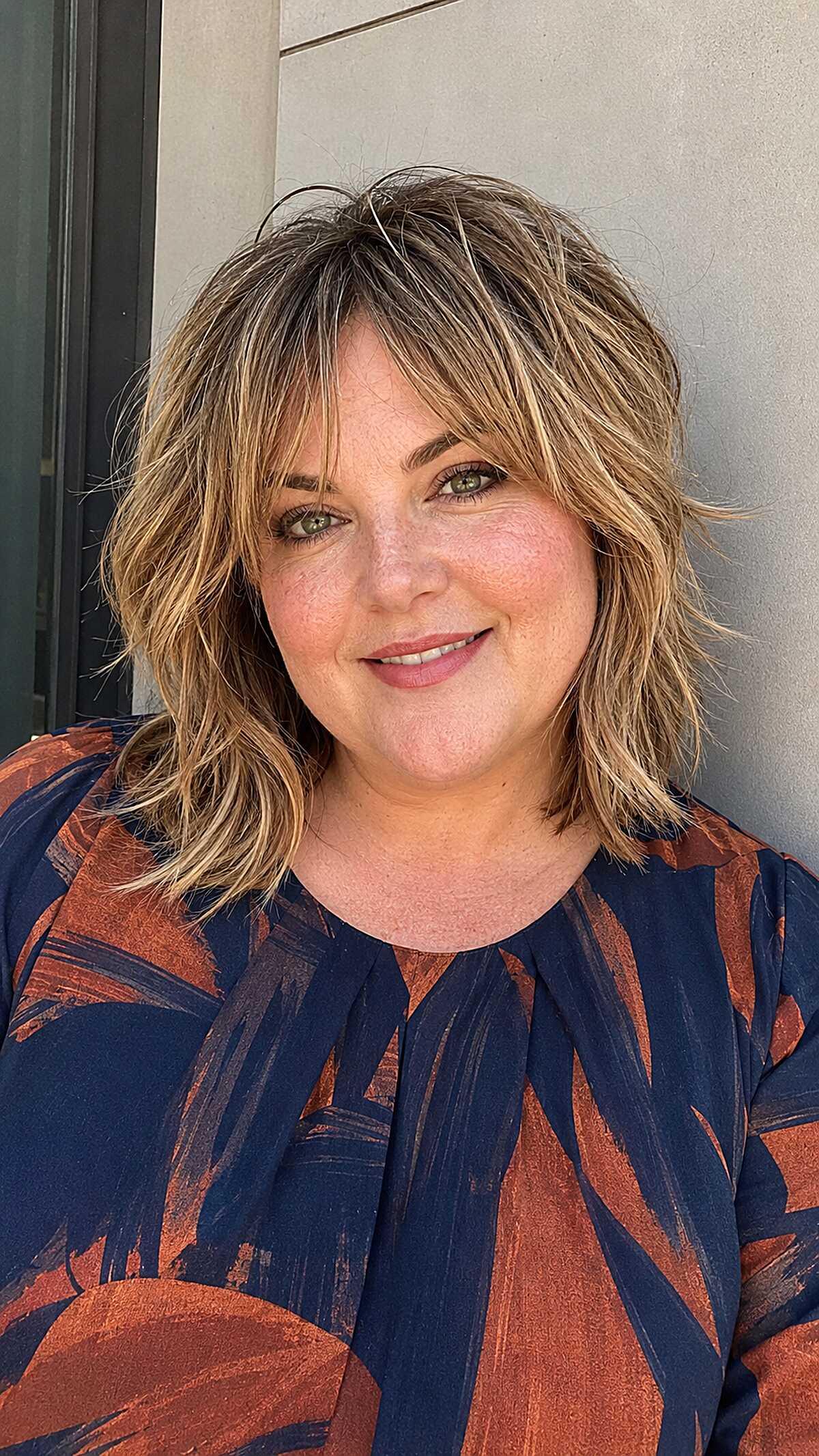 Tousled chin-length blonde shag with dark roots