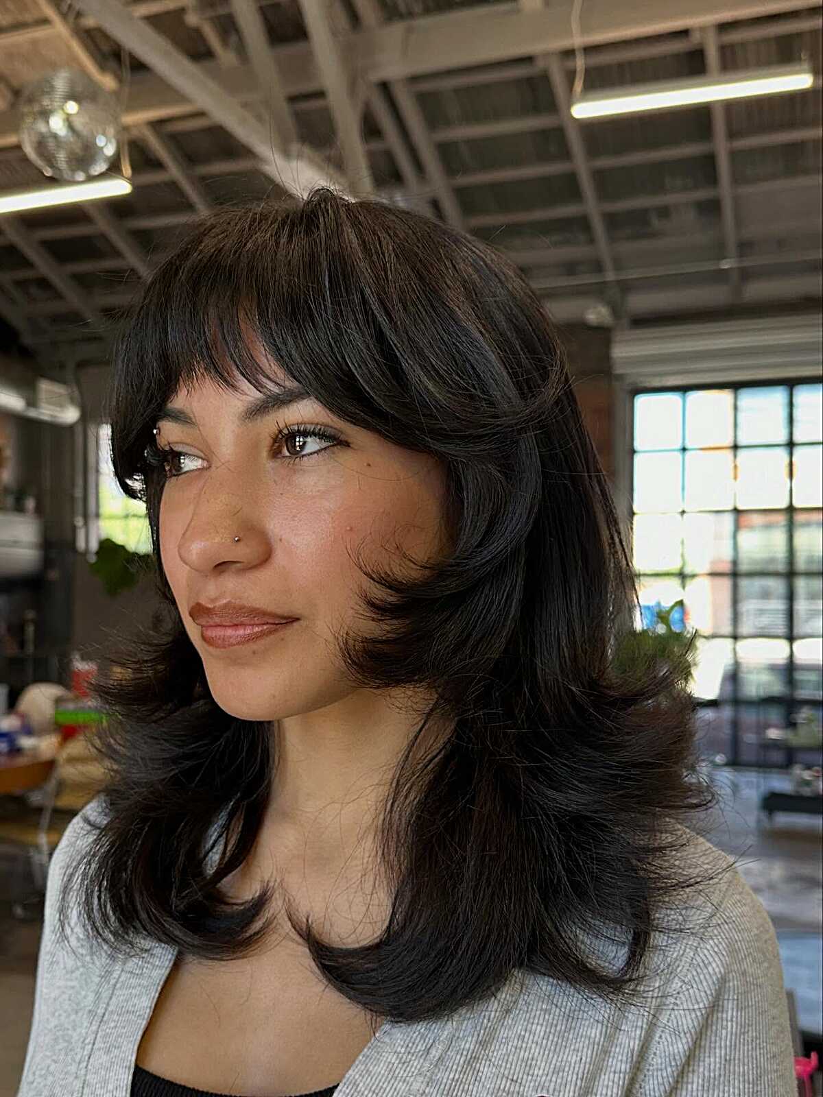 Dark voluminous butterfly cut with curtain bangs