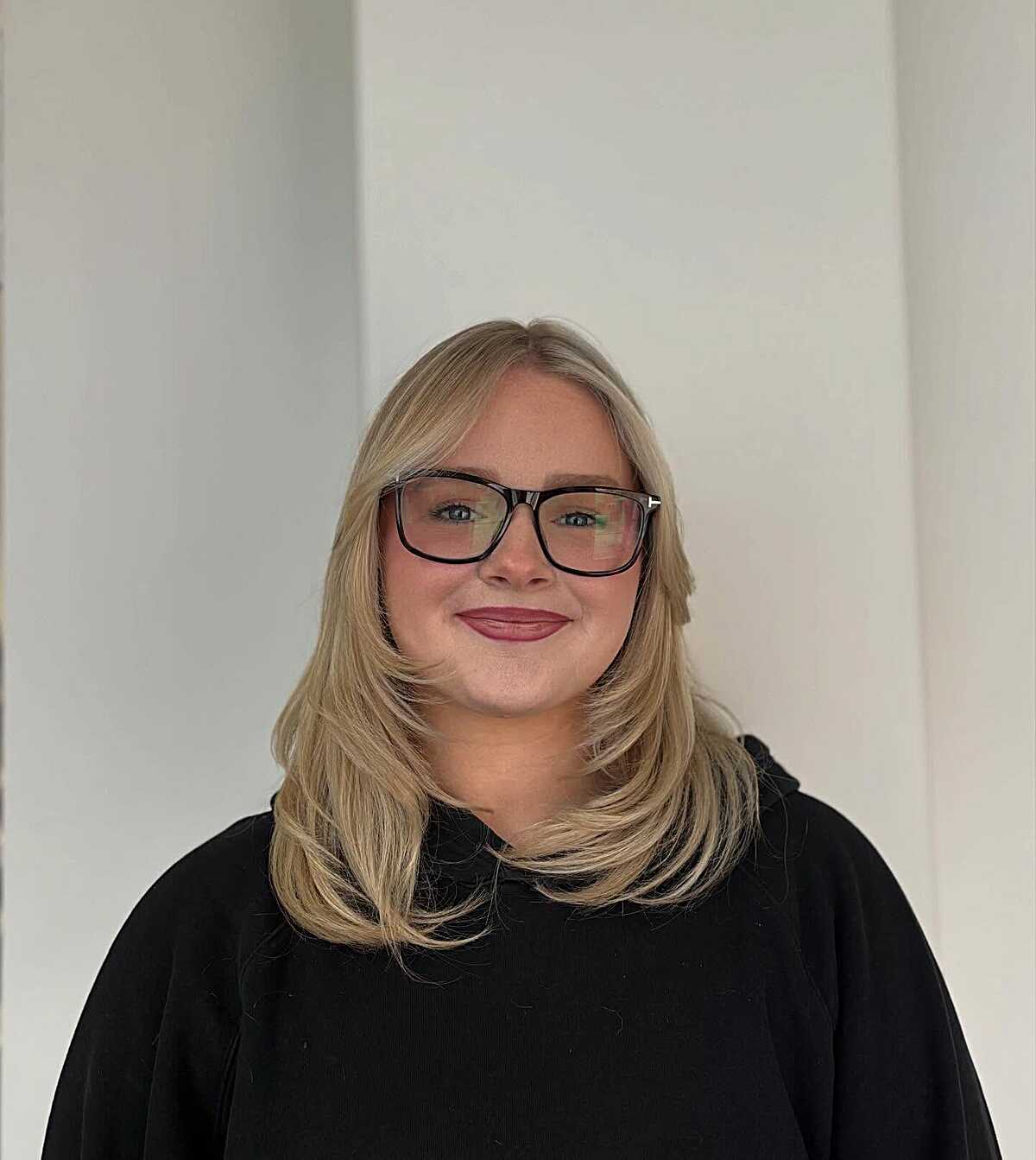 Warm blonde mid-length blowout with side-swept layers