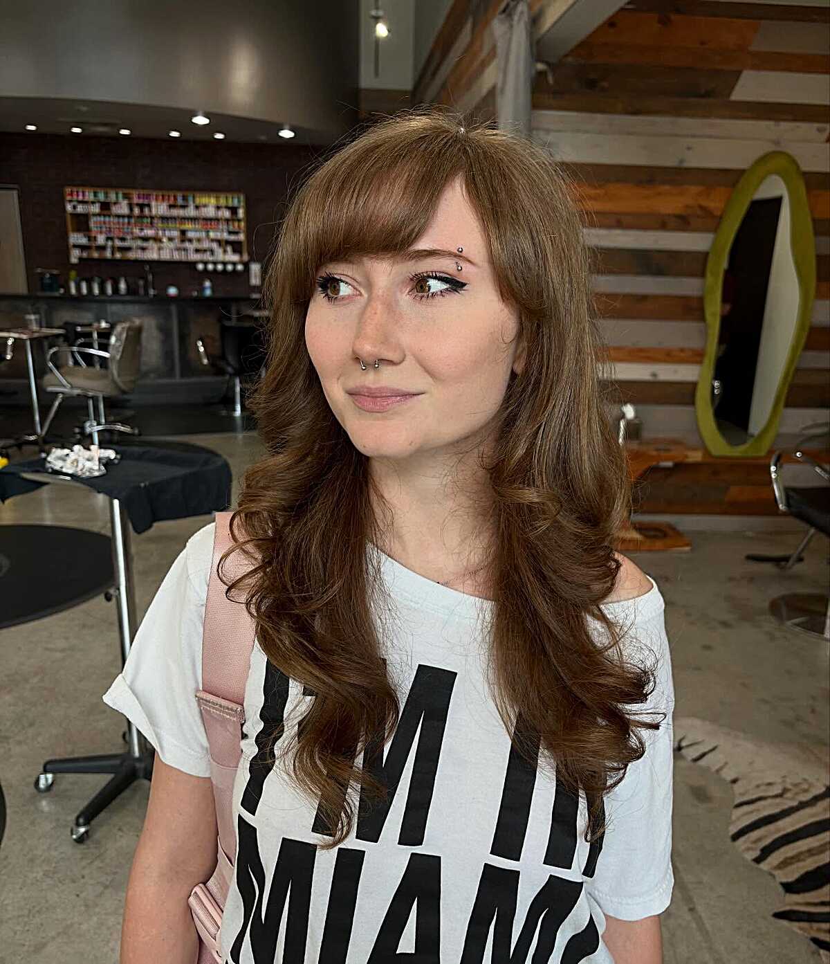 Long warm brown wavy hair with wispy arched side bangs