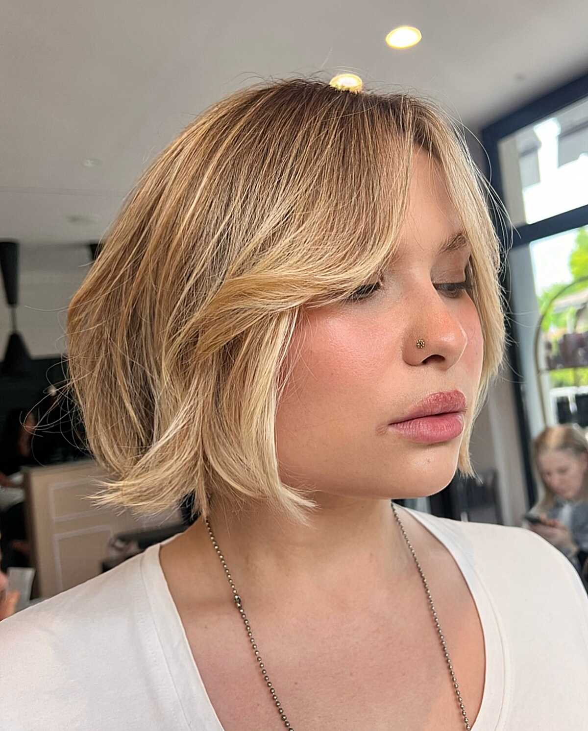 Bronde chin-length bob with curtain bangs and soft wave