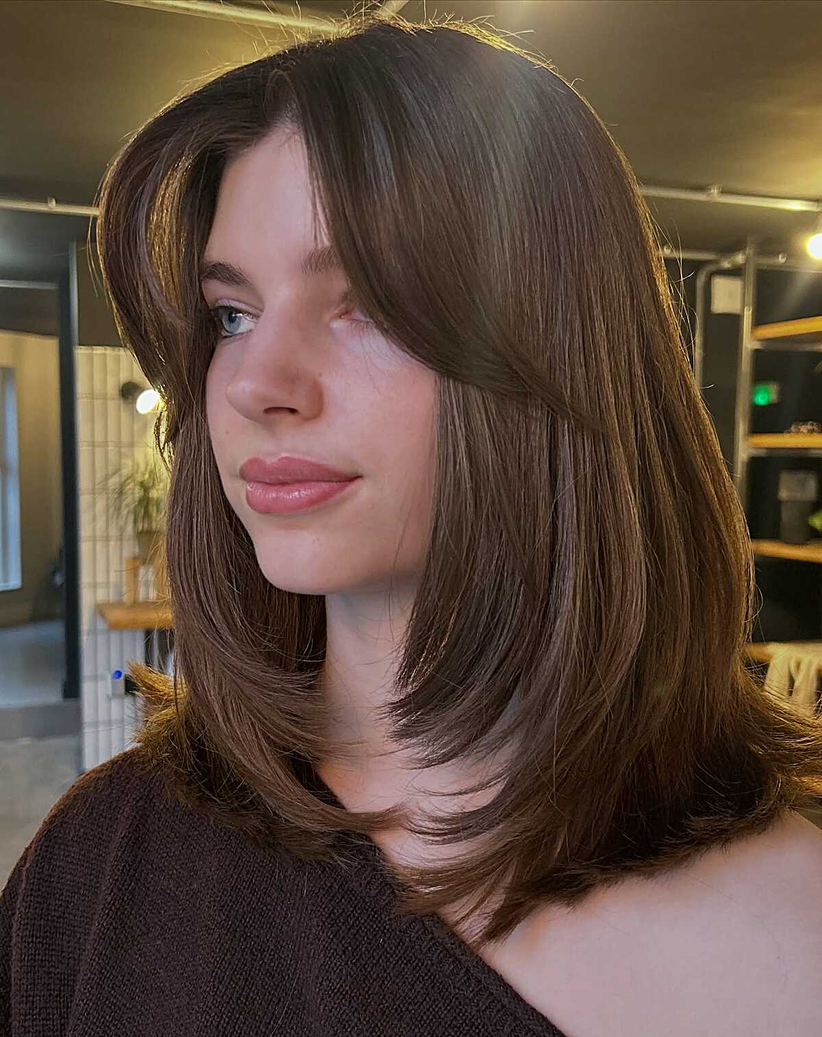 Chestnut brown lob with side-swept layers and volume