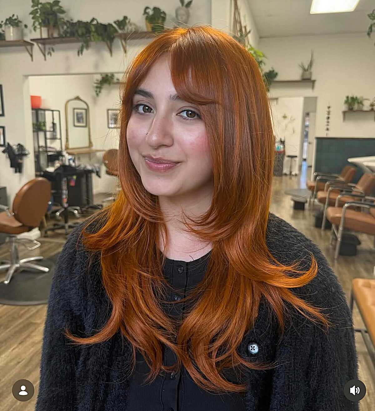 Long copper hair with curtain bangs and feathered layers