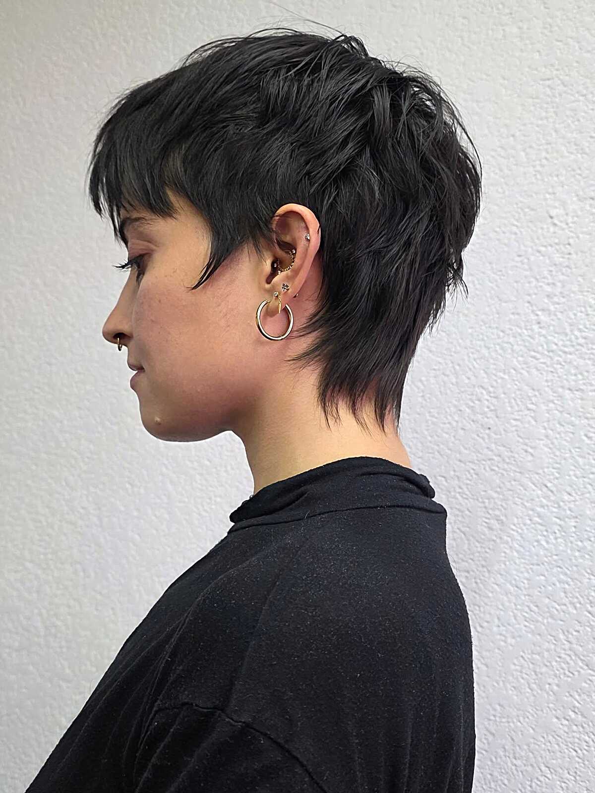 Short black textured pixie with tapered sides and nape