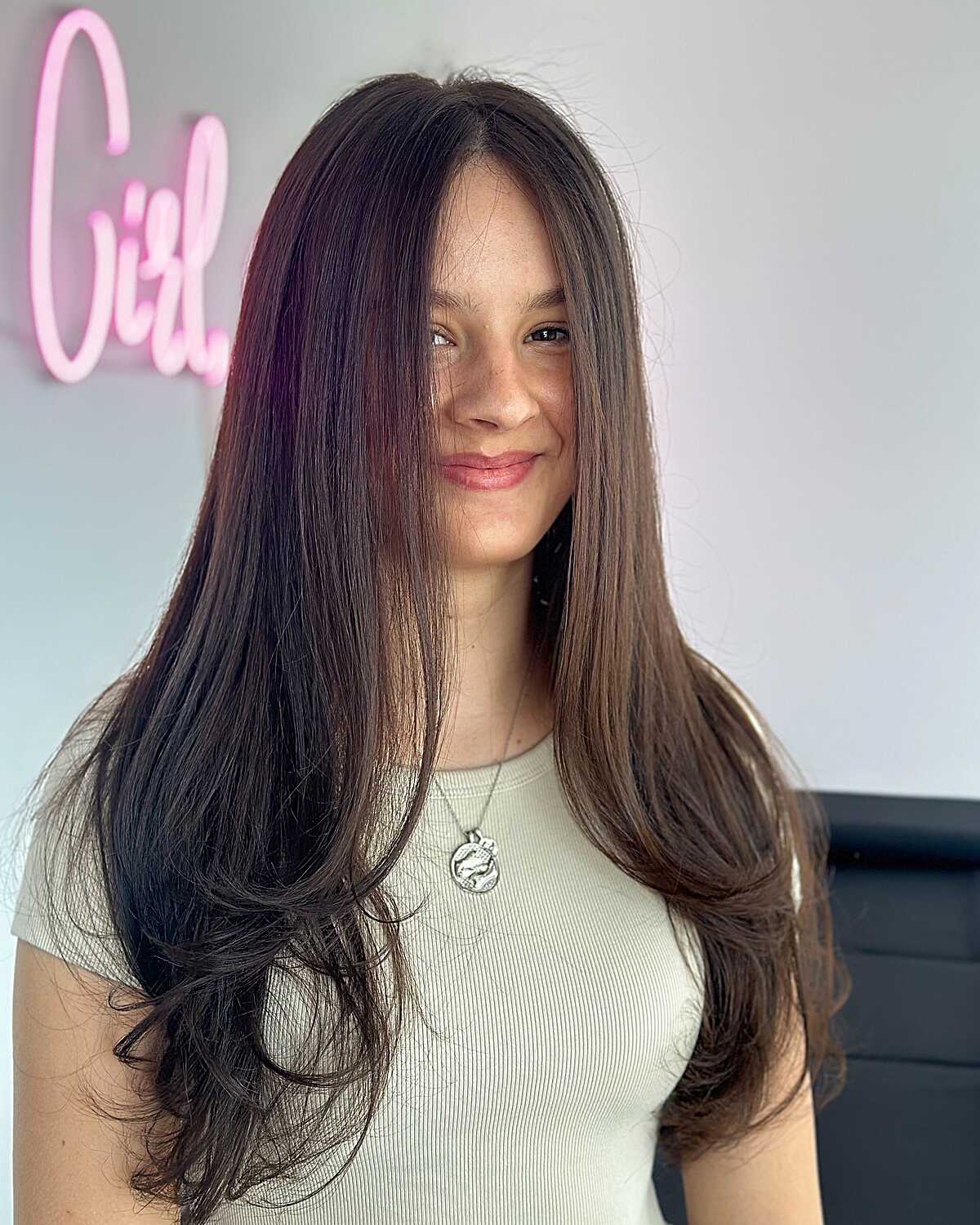 Long dark hair with face-framing layers and flipped ends