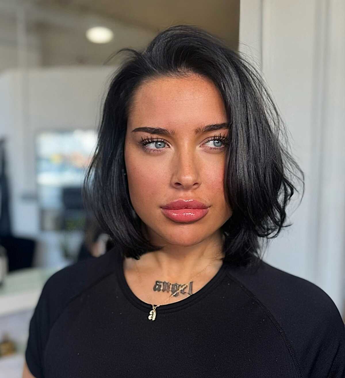 Voluminous jet black bob with loose waves and center part
