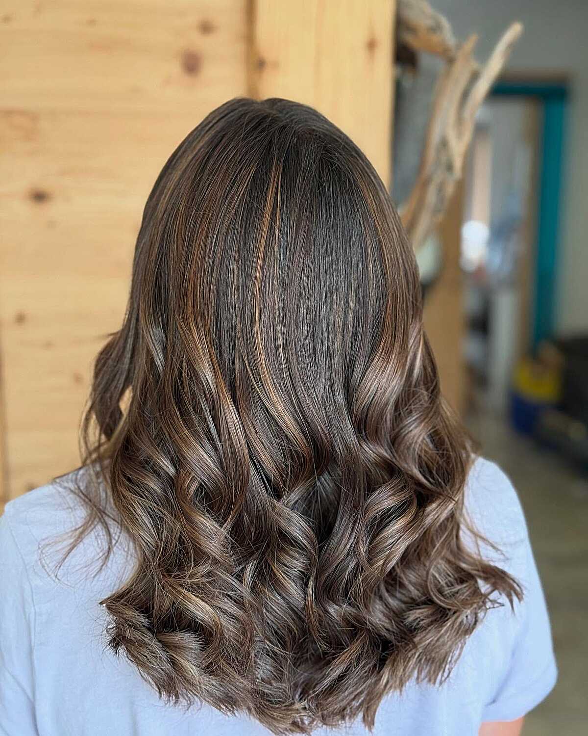 Dark brunette curls with caramel peekaboo highlights
