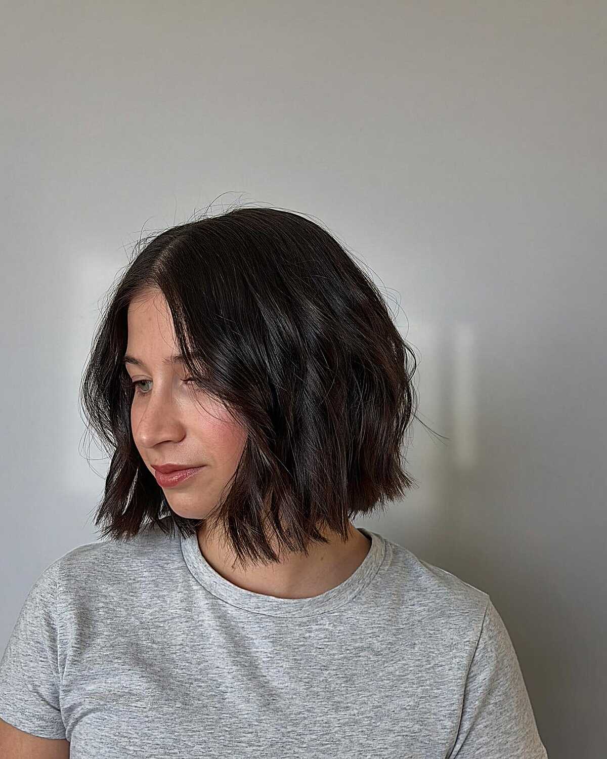 Dark chin-length bob with choppy texture and movement