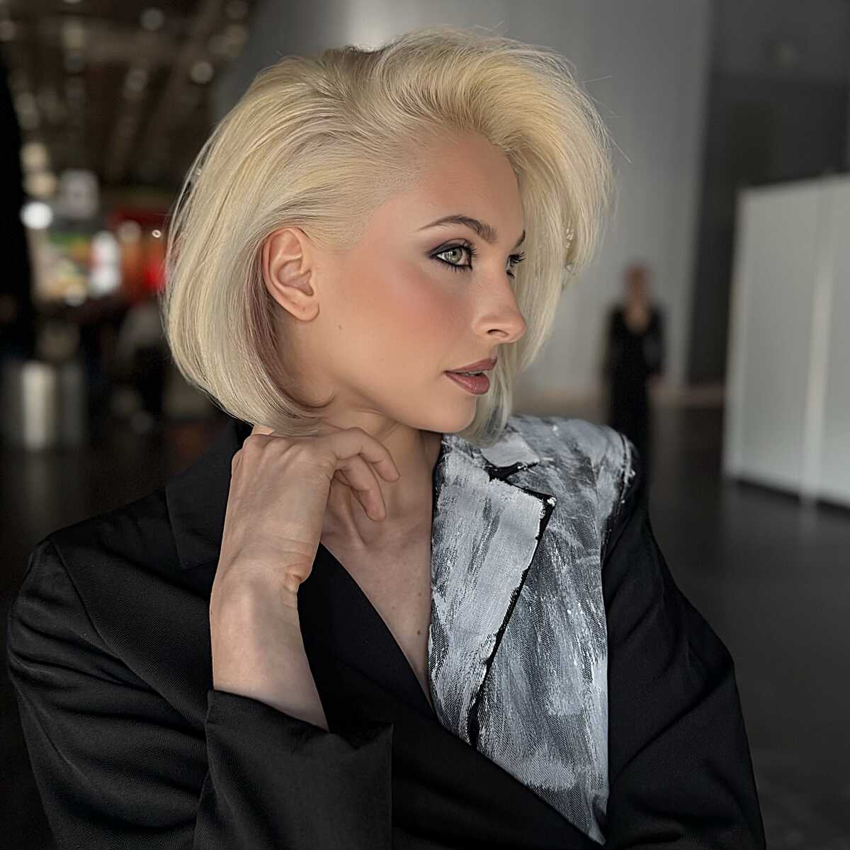 Platinum blonde bob swept back with volume at the crown