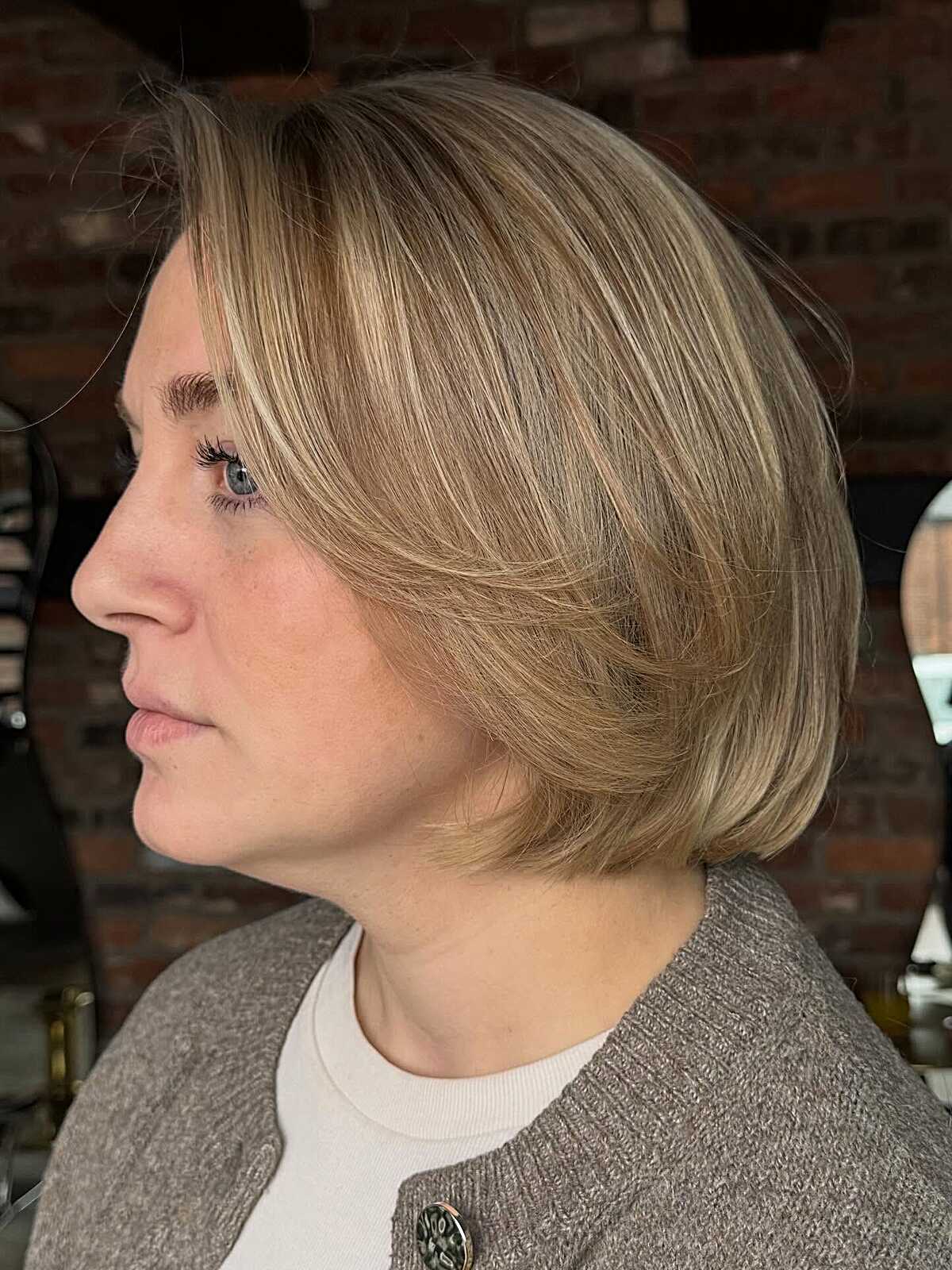 Sandy blonde stacked bob with feathered side bangs