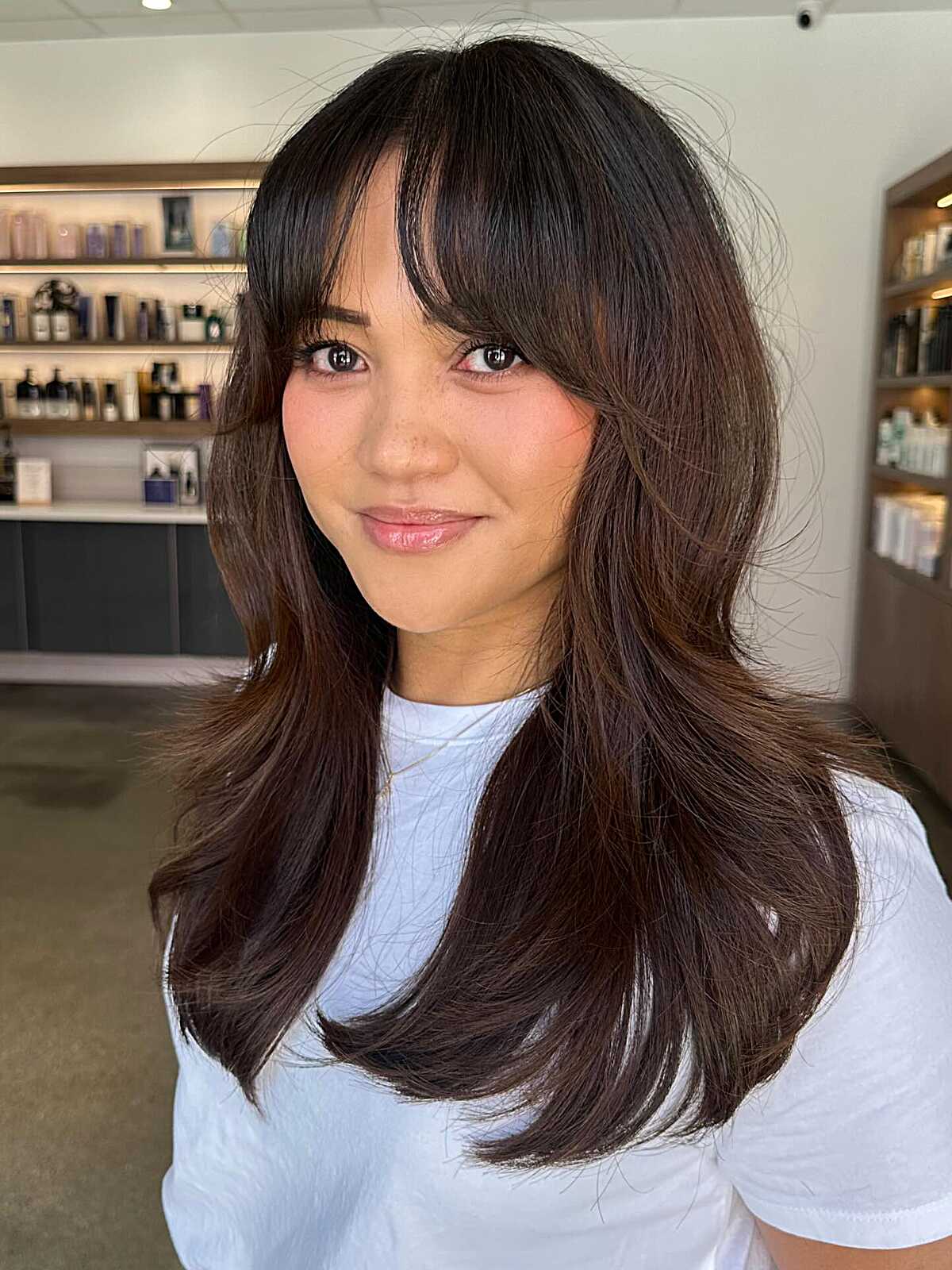 Medium-length chocolate brown hair with wispy bangs