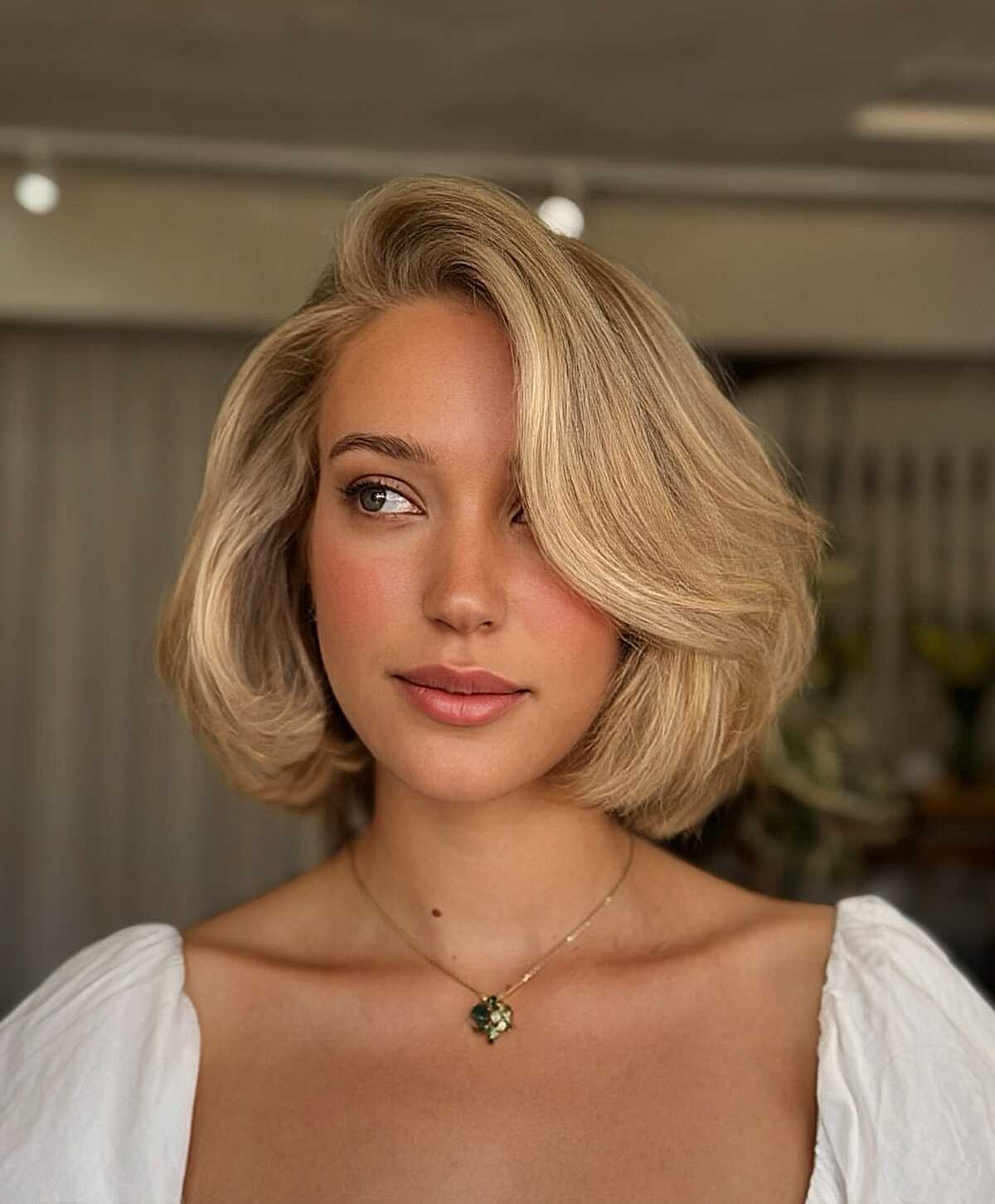 Warm blonde bob with sculpted inward waves and side part