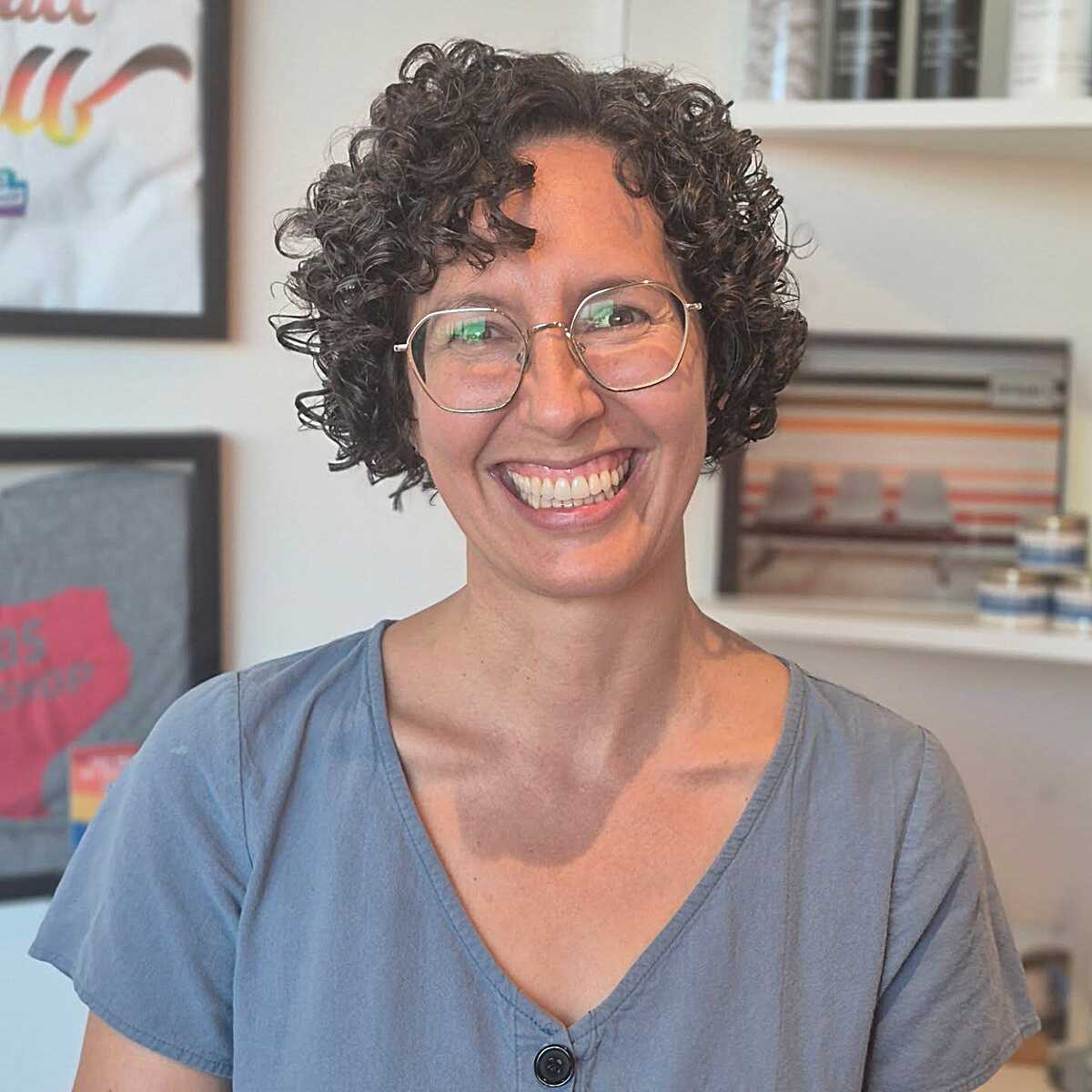 Short dark curly bob with compact ringlets and glasses