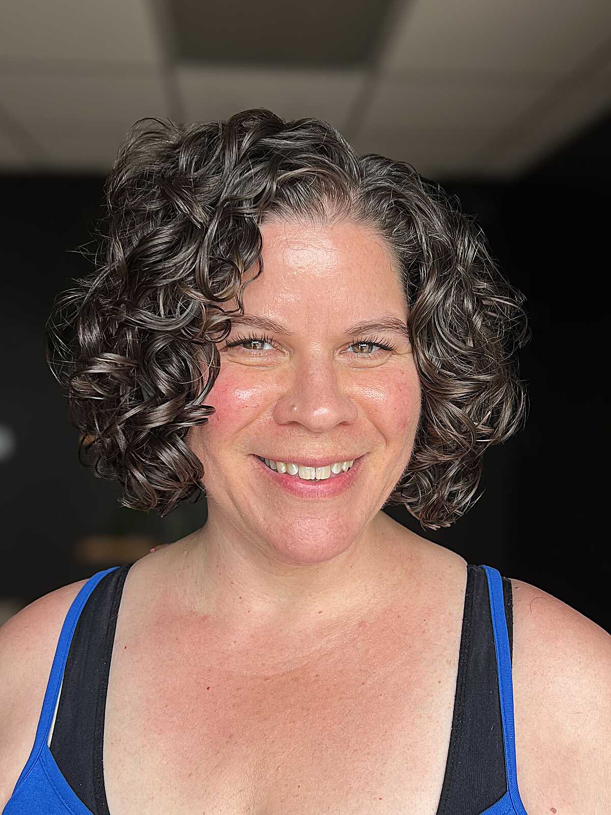 Brunette curly bob with deep side part and full body