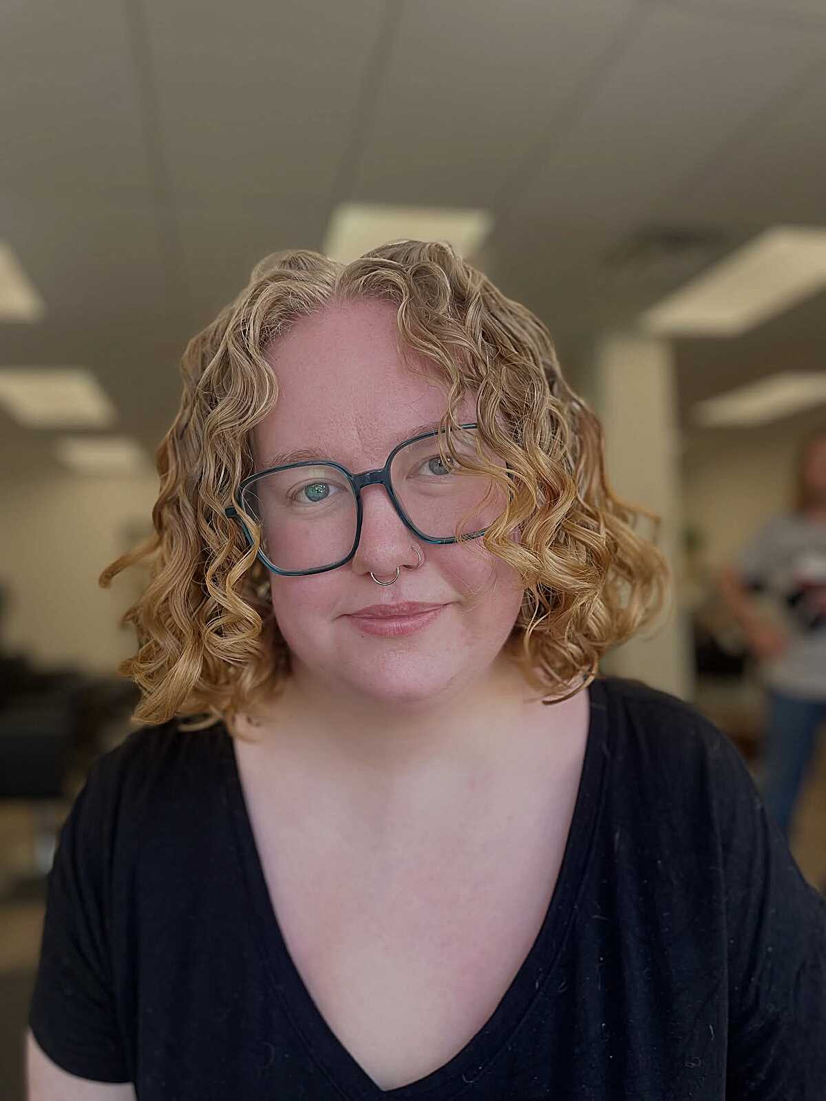 Golden blonde curly lob with spiral curls and dark roots