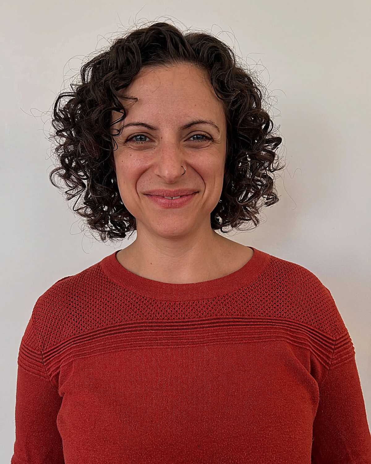 Dark chocolate spiral curly bob at chin length
