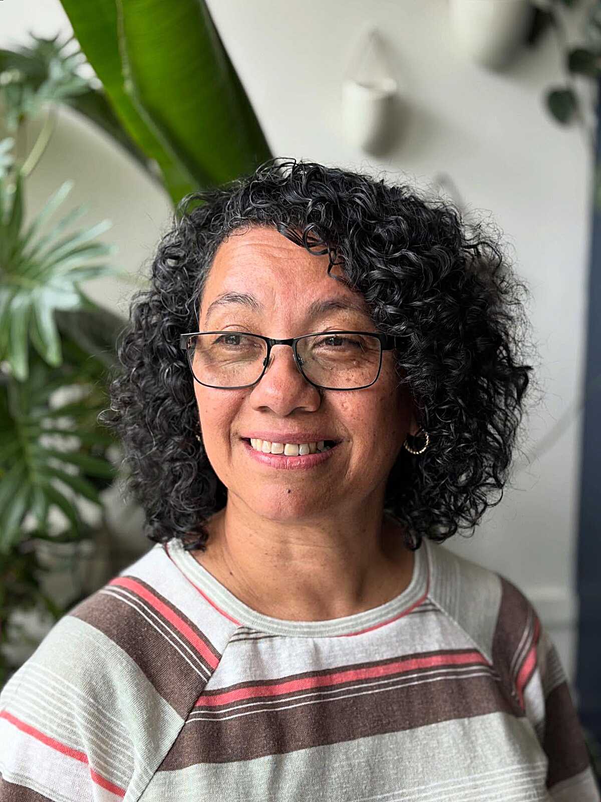 Salt and pepper curly bob with glasses on mature woman