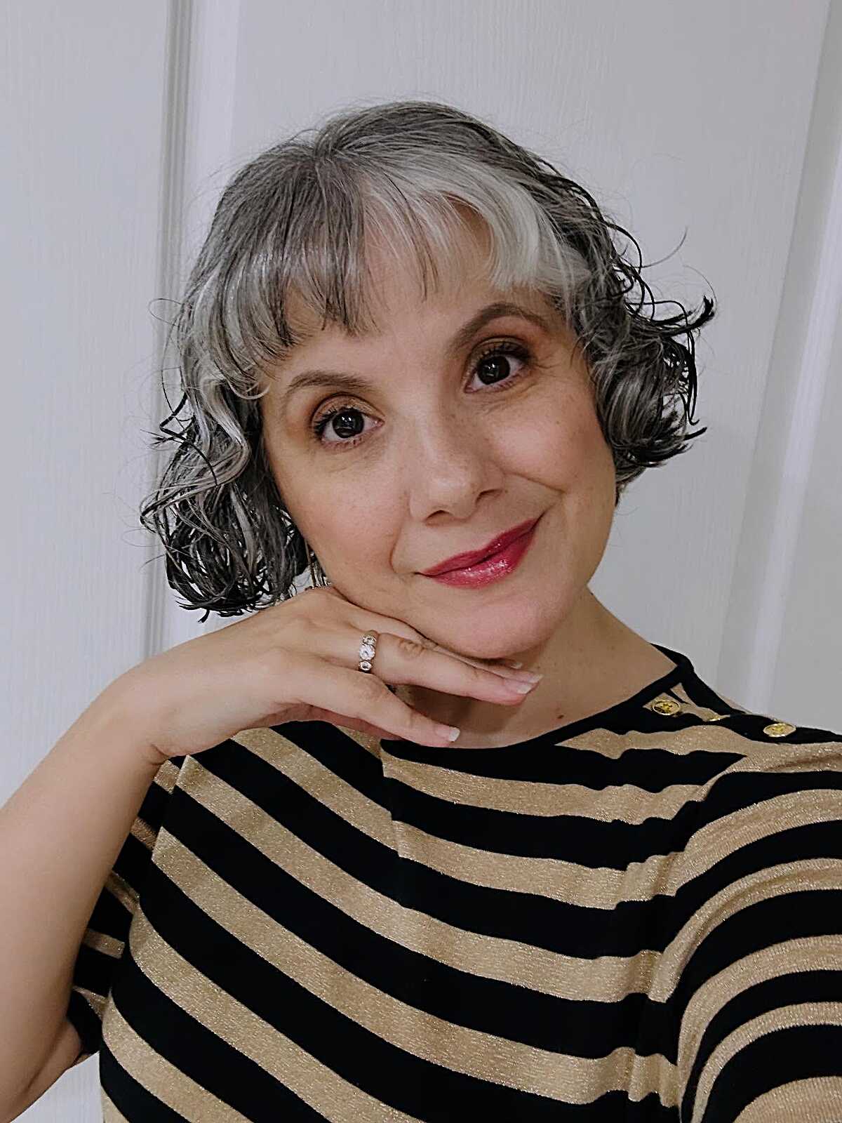 Silver and black wavy bob with curly bangs and red lip