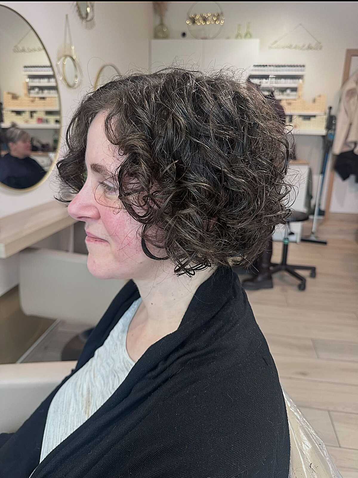 Side view of stacked dark curly bob with graduation