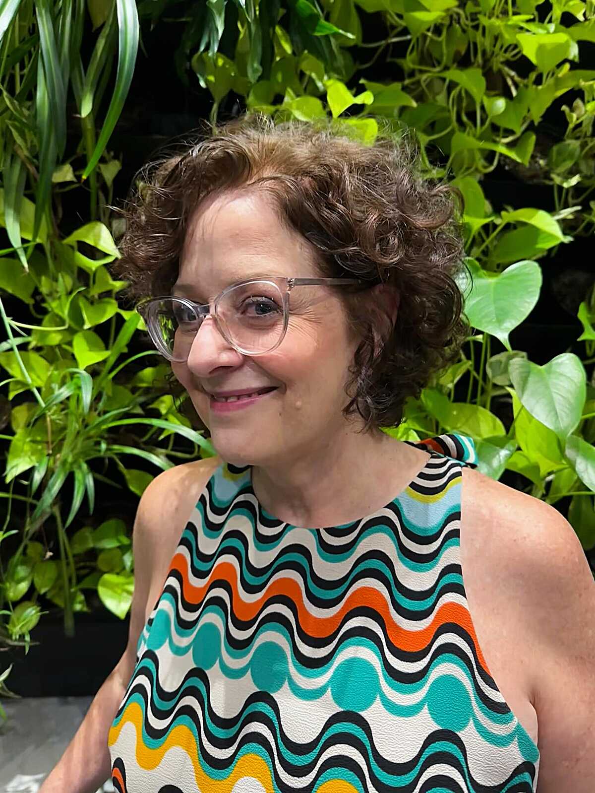 Short auburn curly bob with retro glasses and freckles
