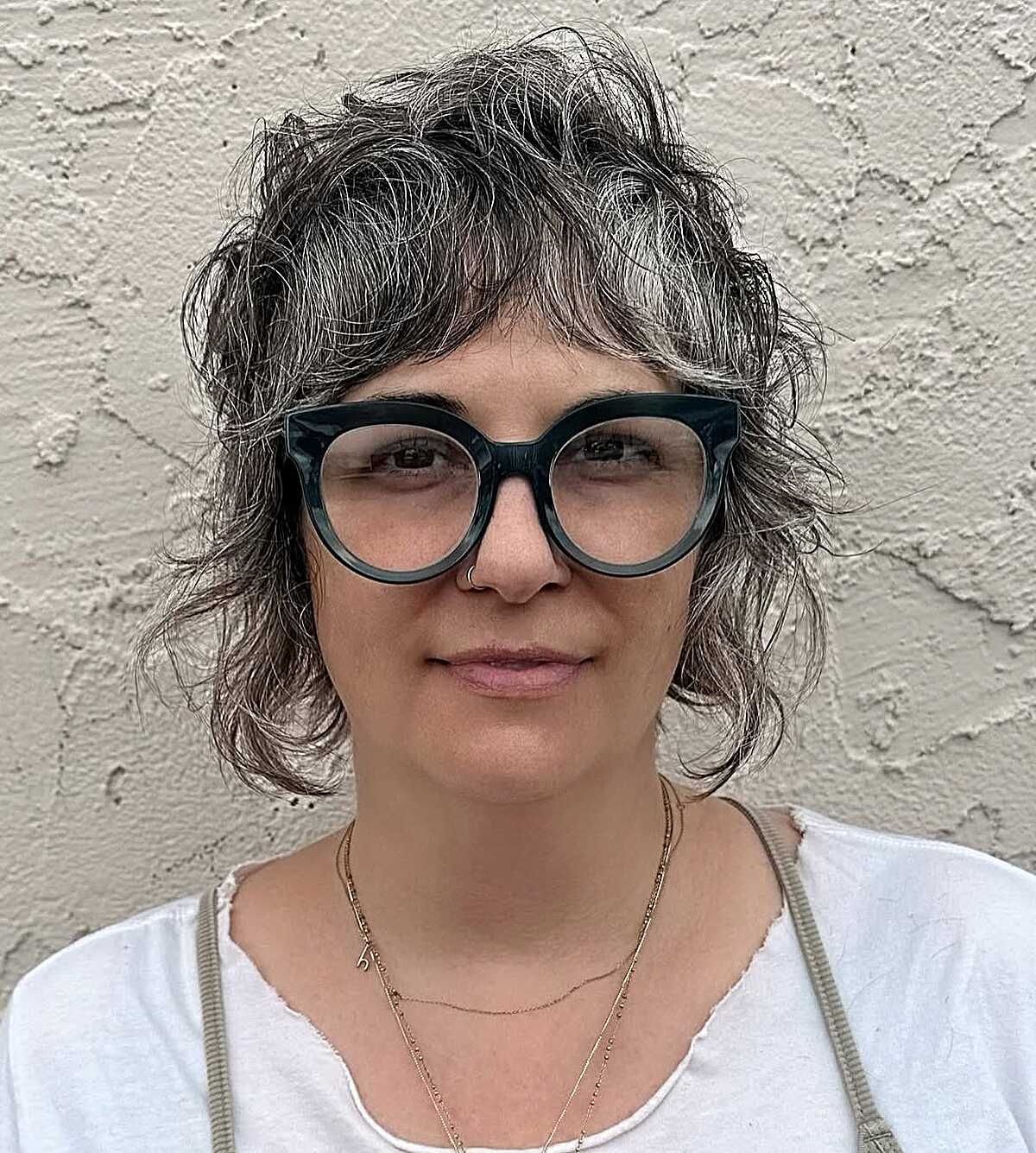 Curly dark gray bob shag with oversized glasses