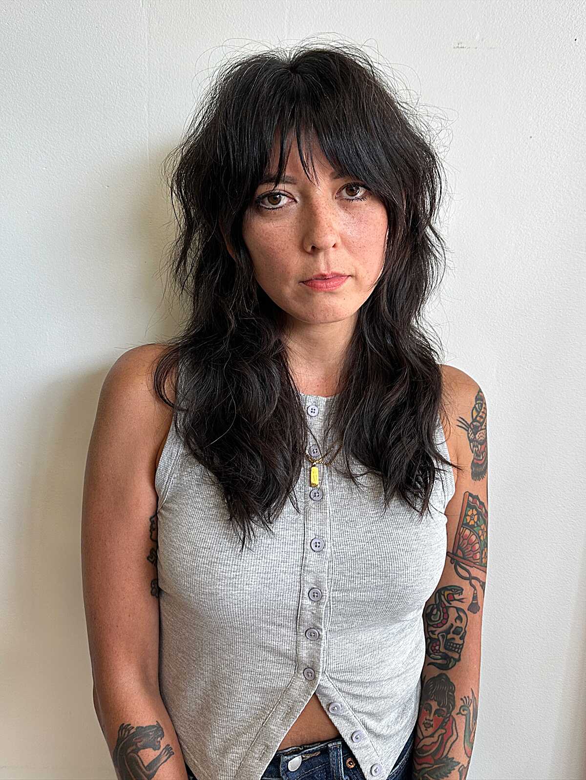 Dark wavy shag haircut with choppy bangs and layers