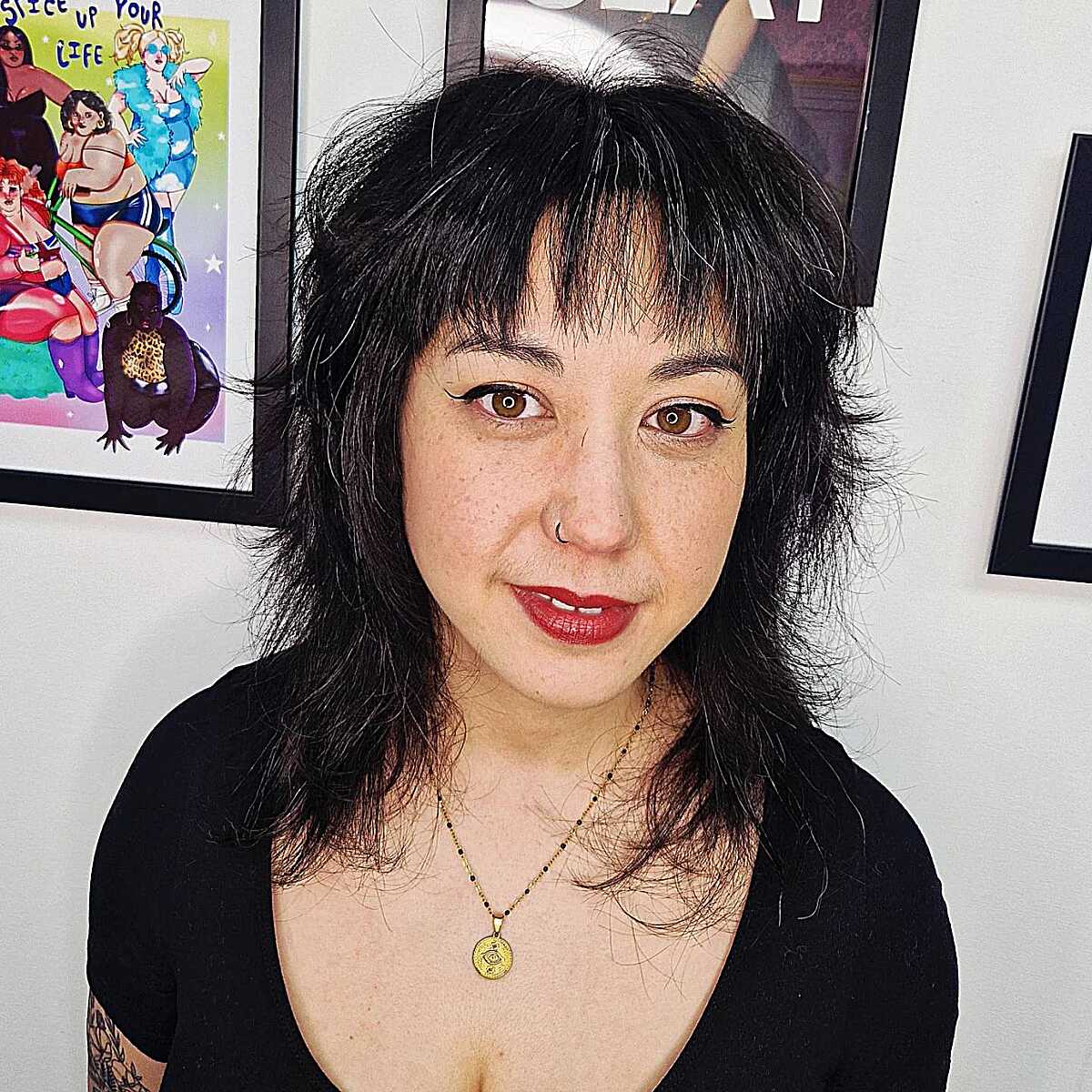 Jet black chin-length textured shag with blunt bangs