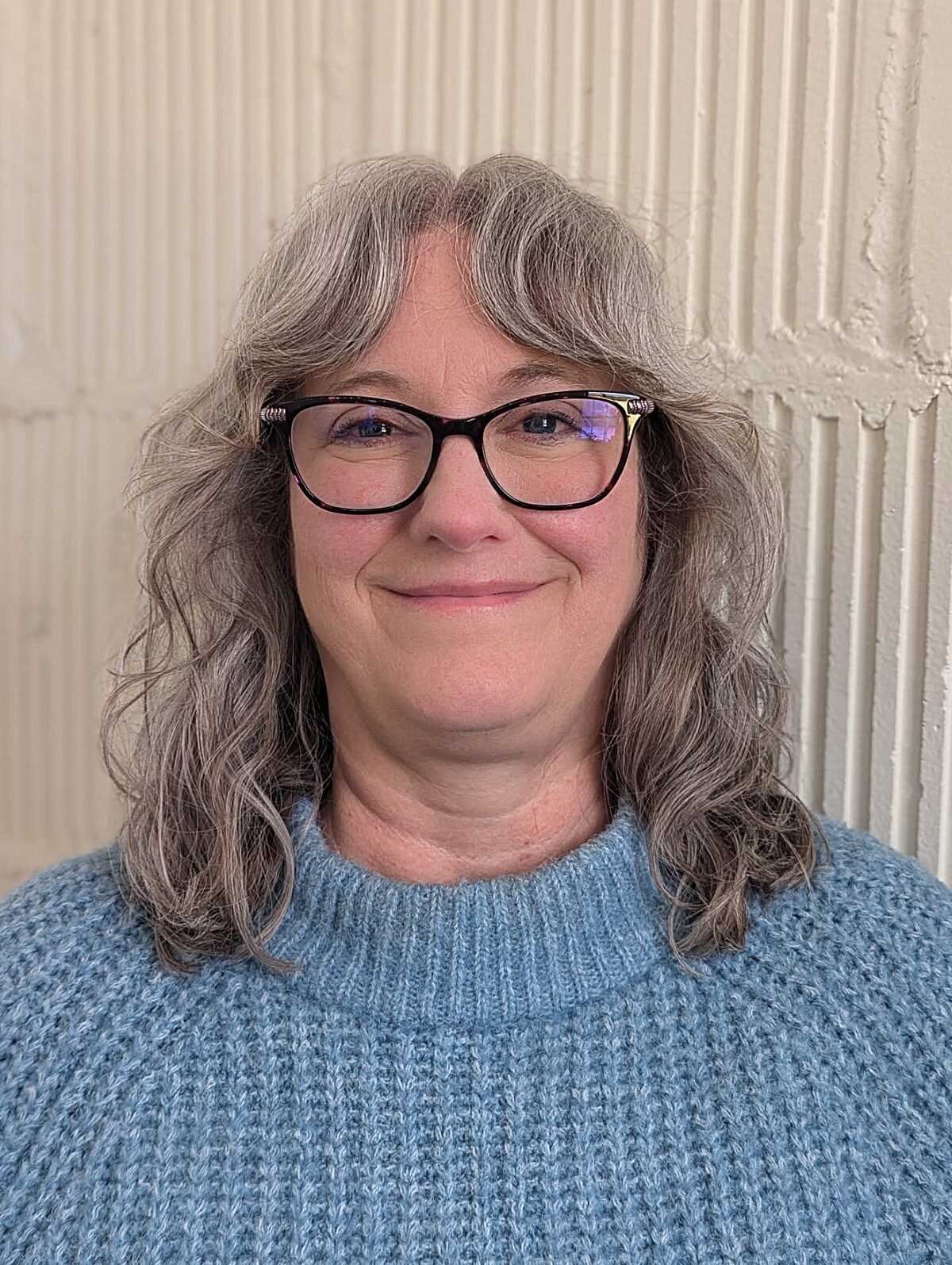 Shoulder-length wavy gray shag with glasses