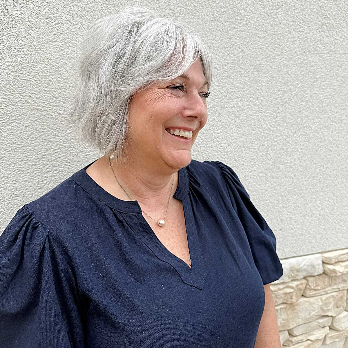 Silver white shaggy bob with side-swept layers