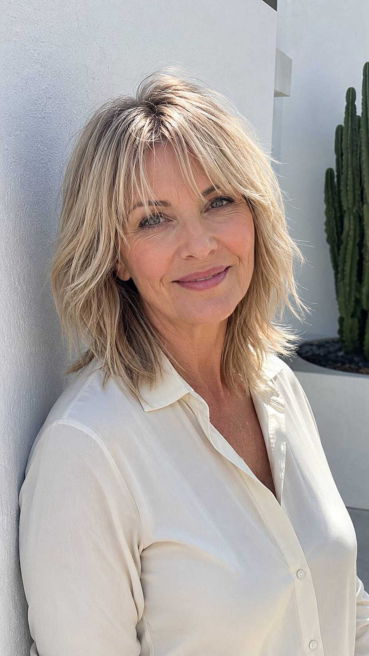 Shoulder-length blonde shag with wispy feathered bangs