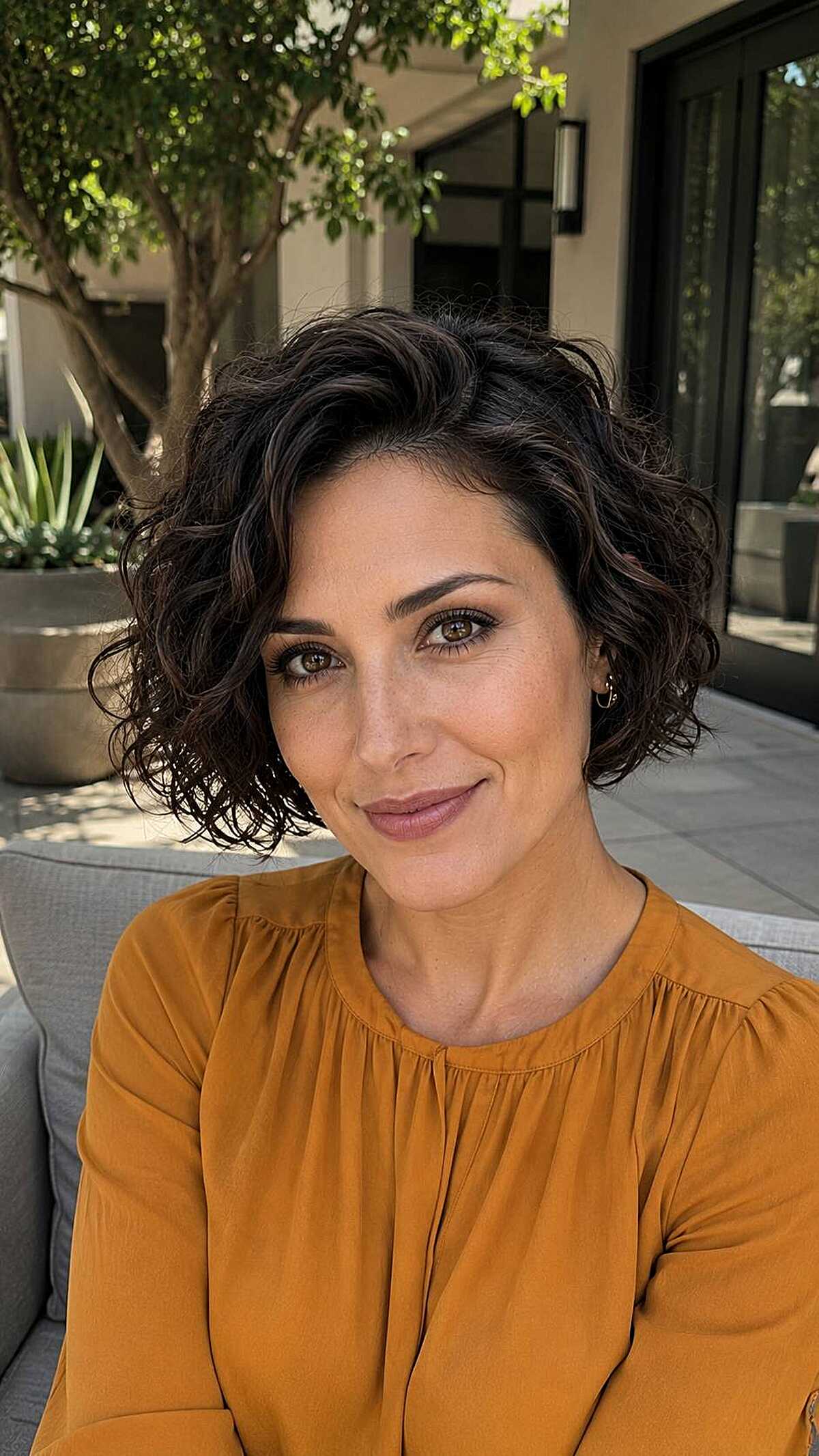 Dark curly chin-length bob with a deep side part
