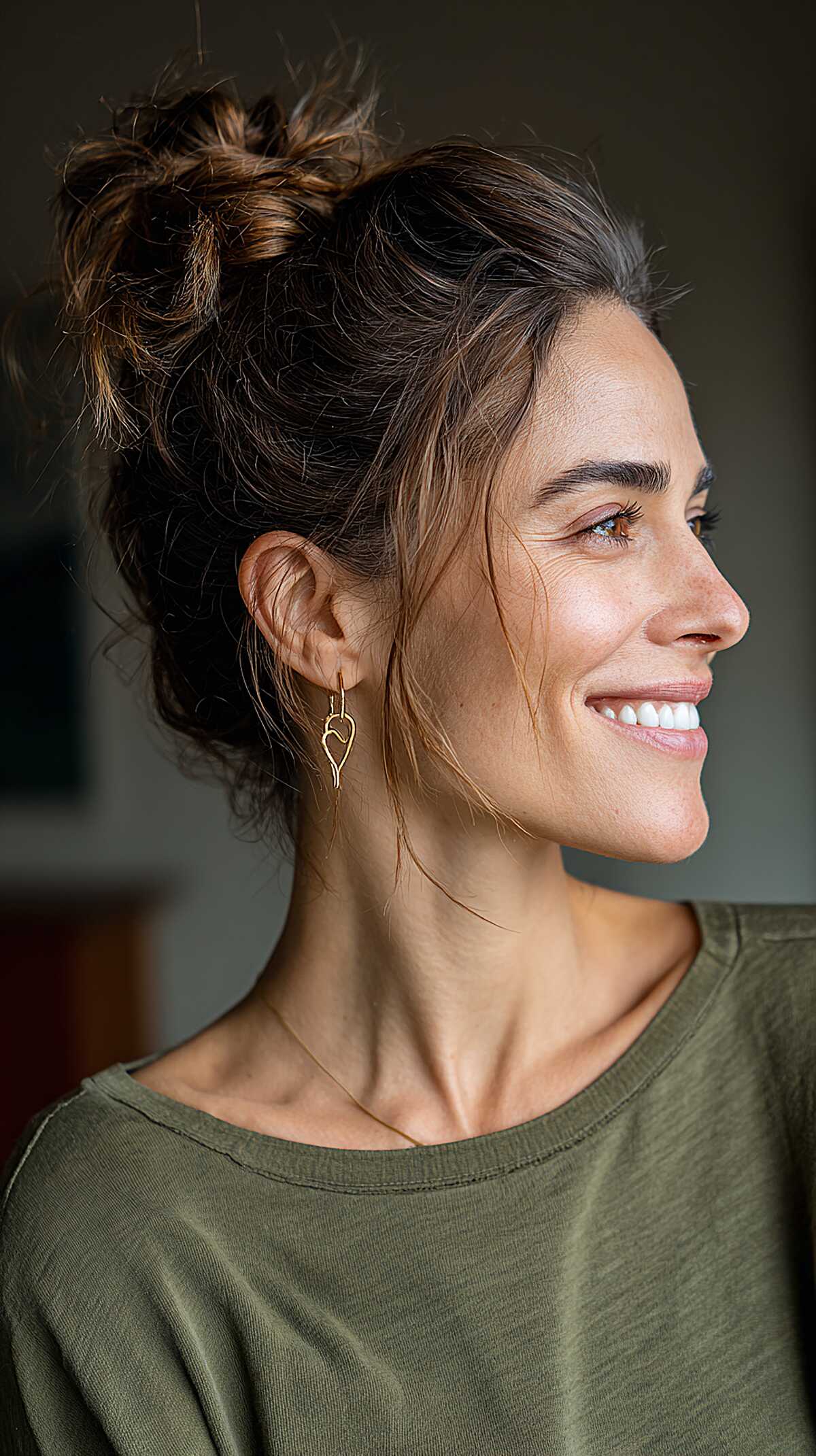 High brunette messy top knot with wispy nape pieces