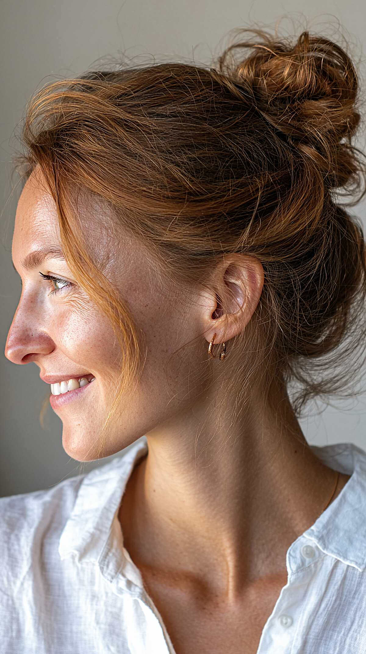 Copper redhead messy high bun with loose layers