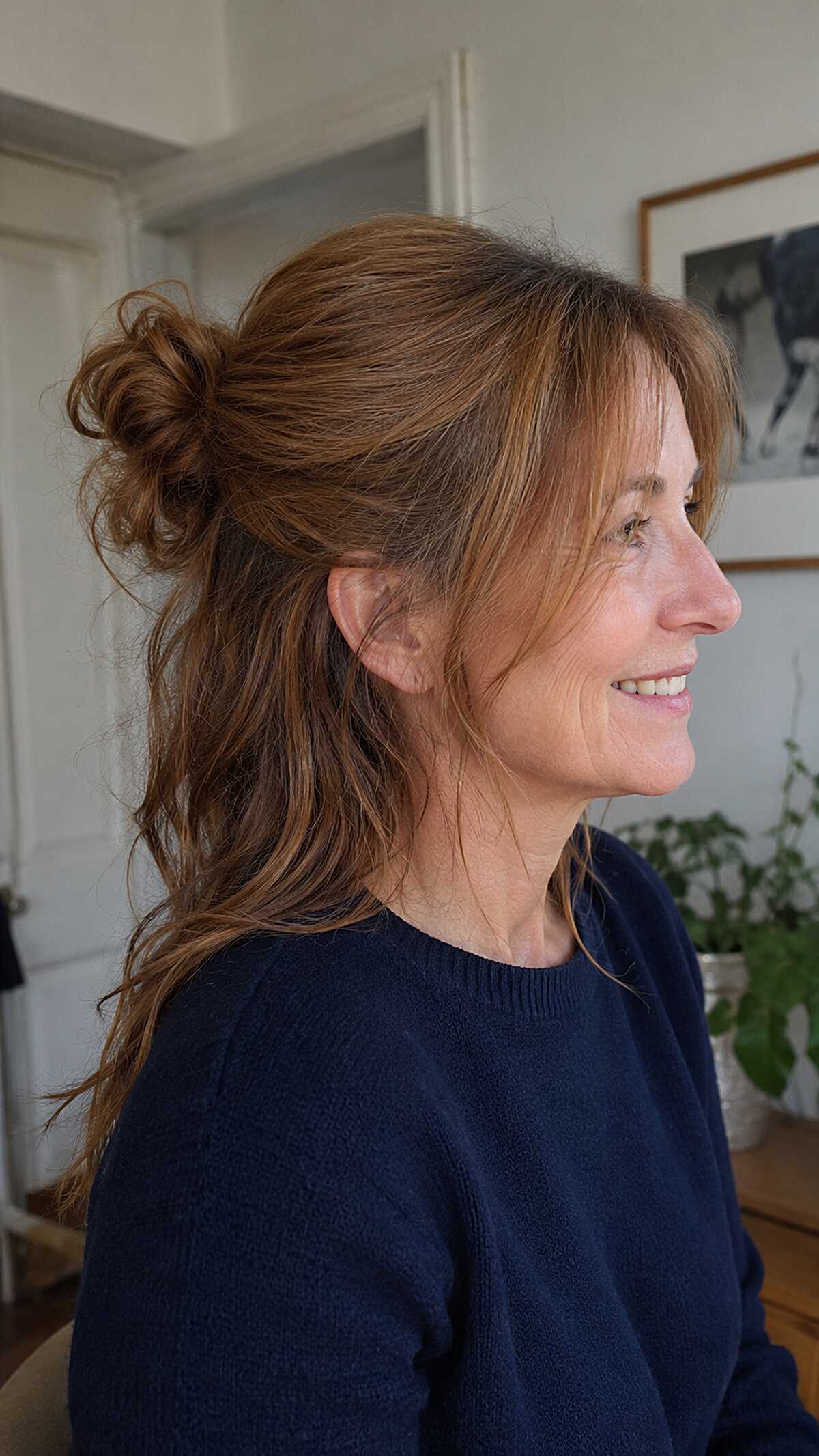 Half-up messy bun on long layered auburn hair