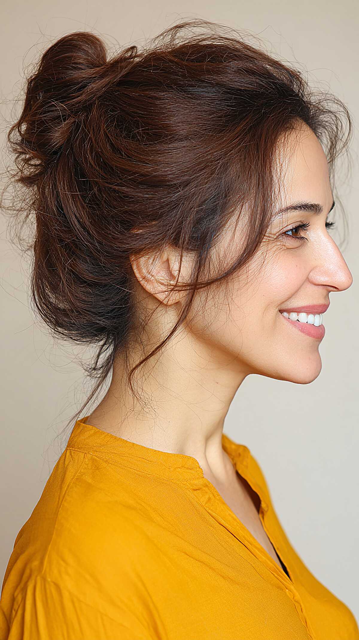Voluminous dark messy bun with dramatic crown lift