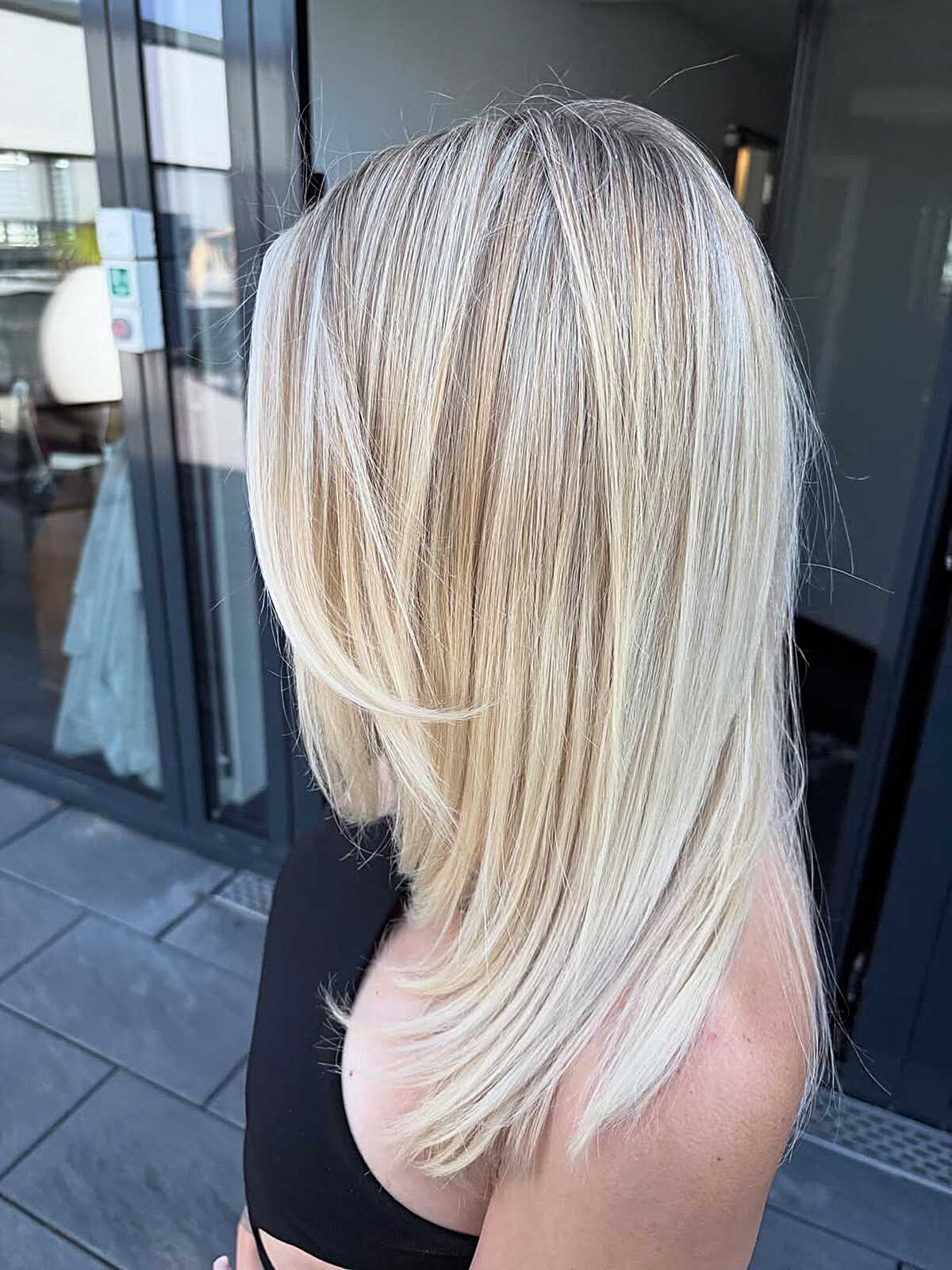 Shoulder-length bright blonde with feathered layered ends