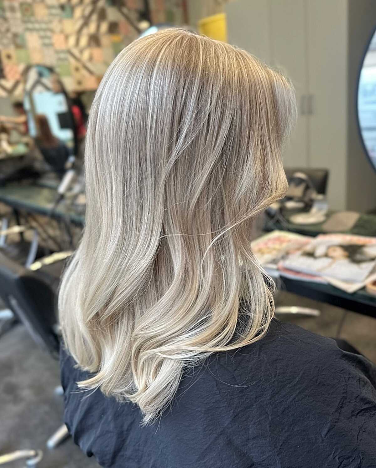 Medium length cool ash blonde lob with smoky roots