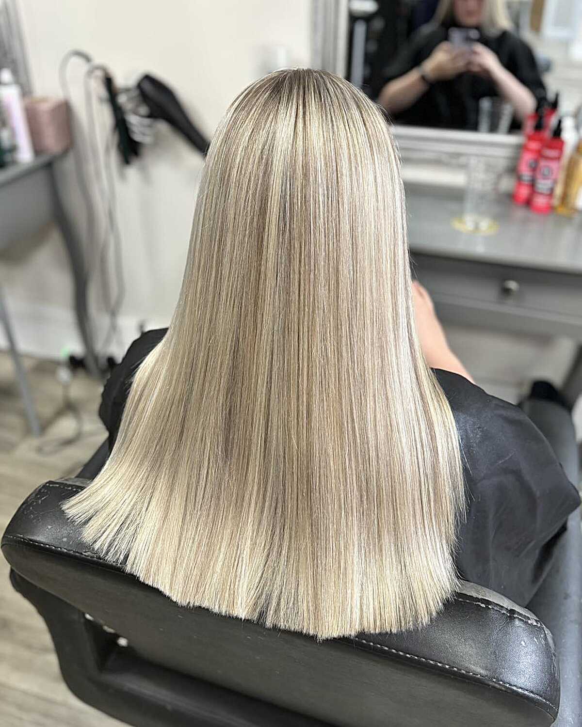 Long flat-ironed icy oat blonde with blended roots